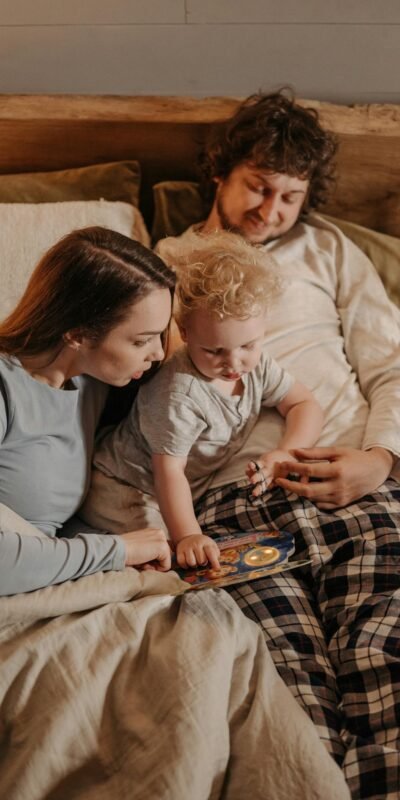 A Couple Spending Time with their Son while Sitting on the Bed