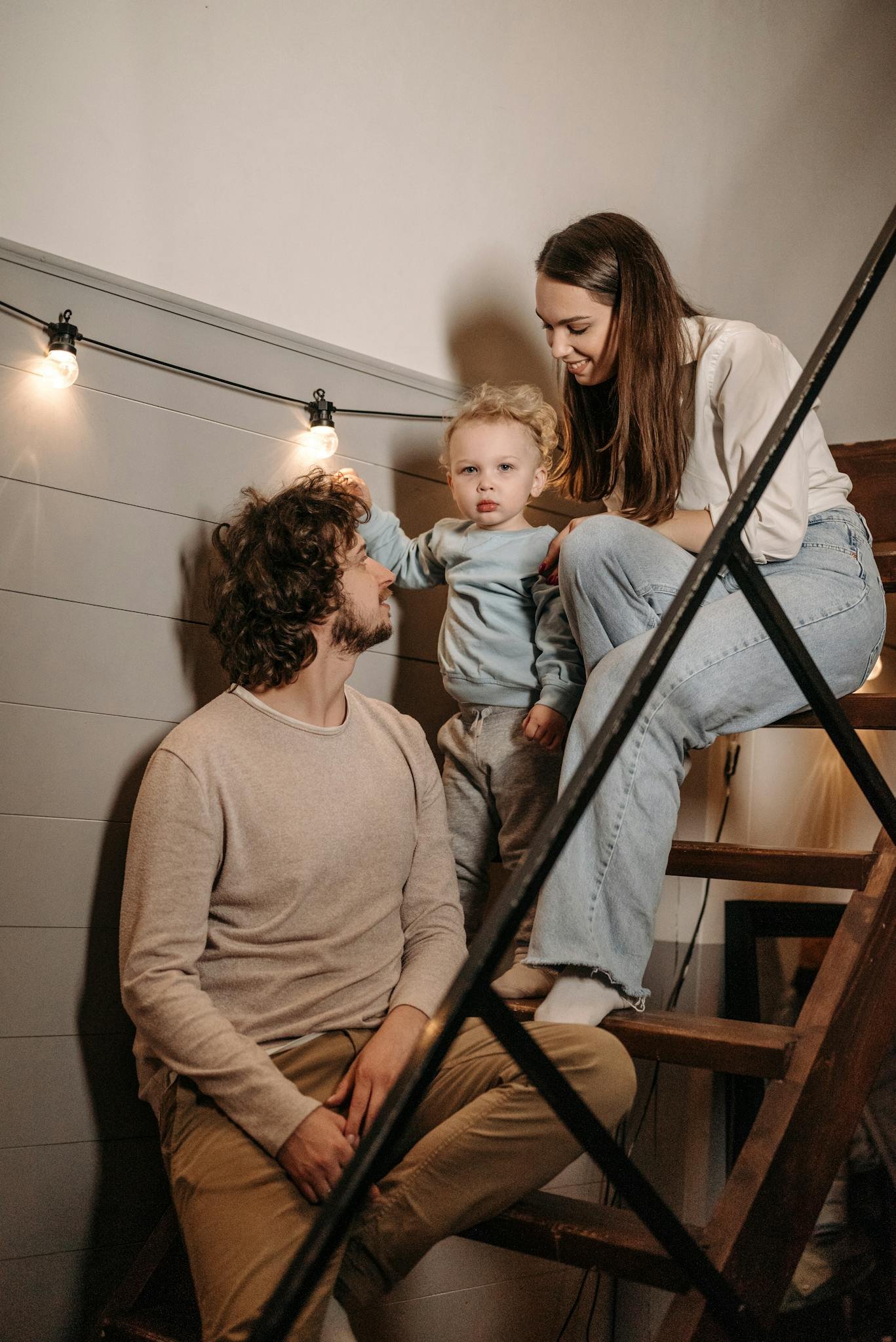 A Man and Woman Sitting on the Stairs with their Son