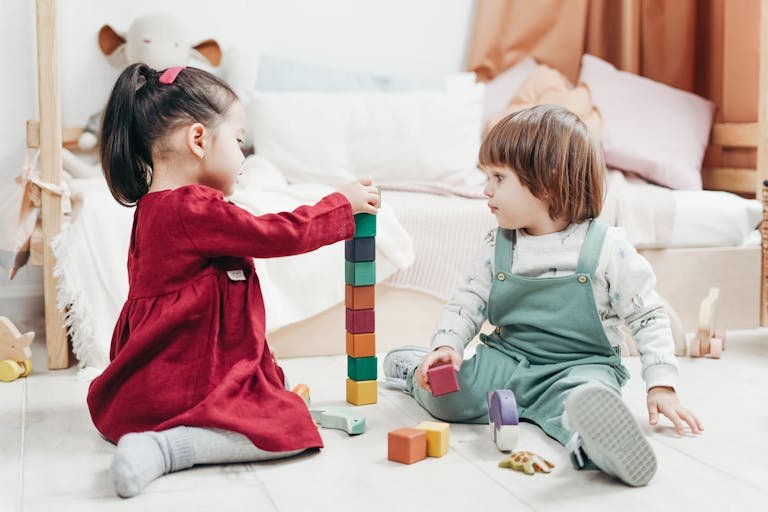 Preschool Age children sitting Playing with blocks